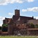 Un gran castillo de ladrillo de estilo gótico con murallas y torres defensivas